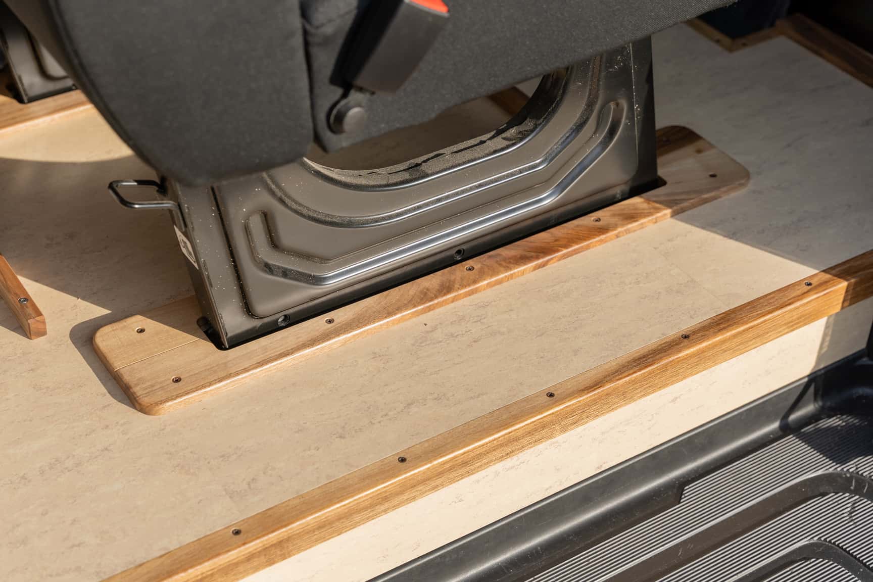 Sand-colored linoleum floor with walnut inlays in the Sprinter L3H2 conversion