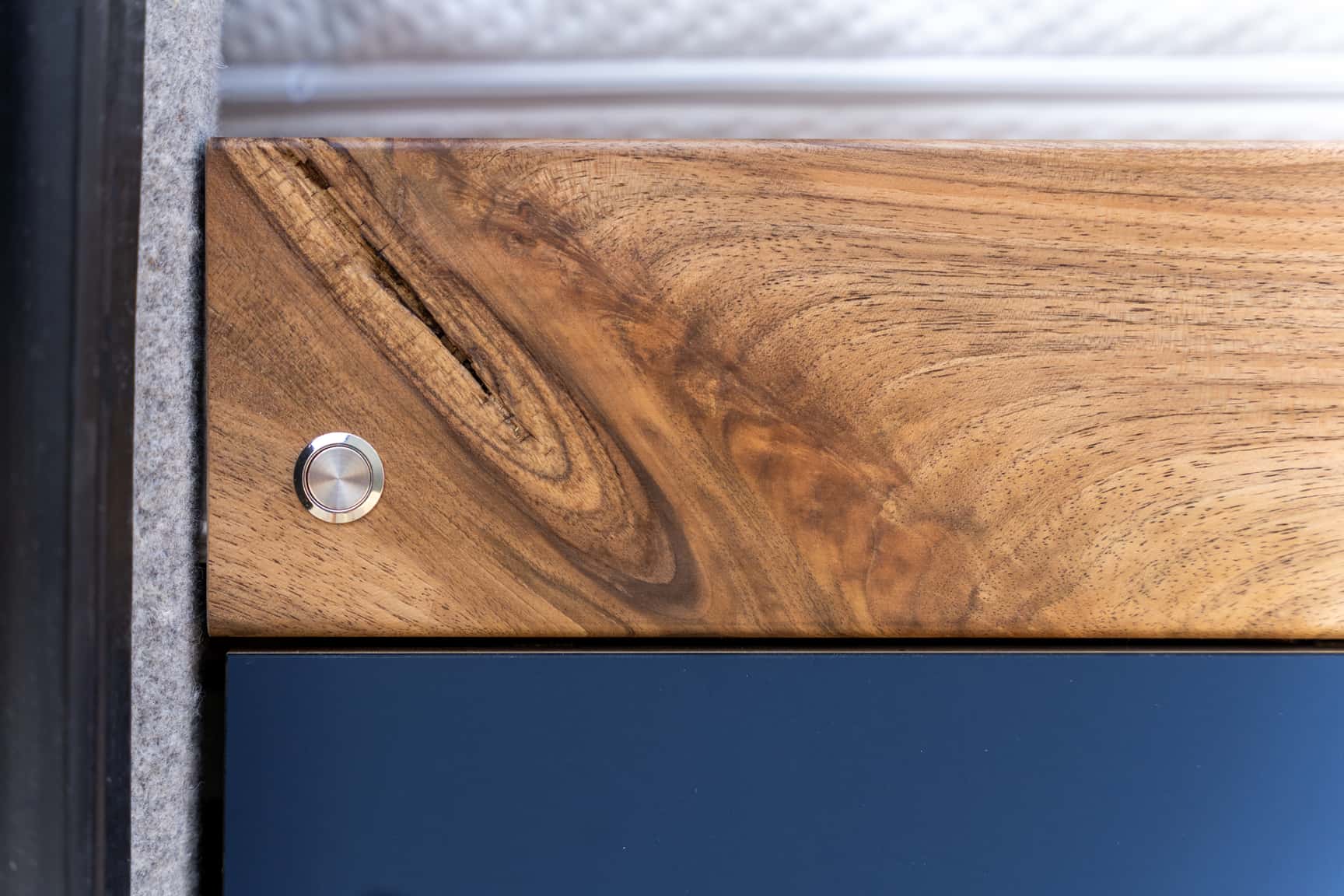 Bed frame in richly grained walnut in the Sprinter L3H2 conversion