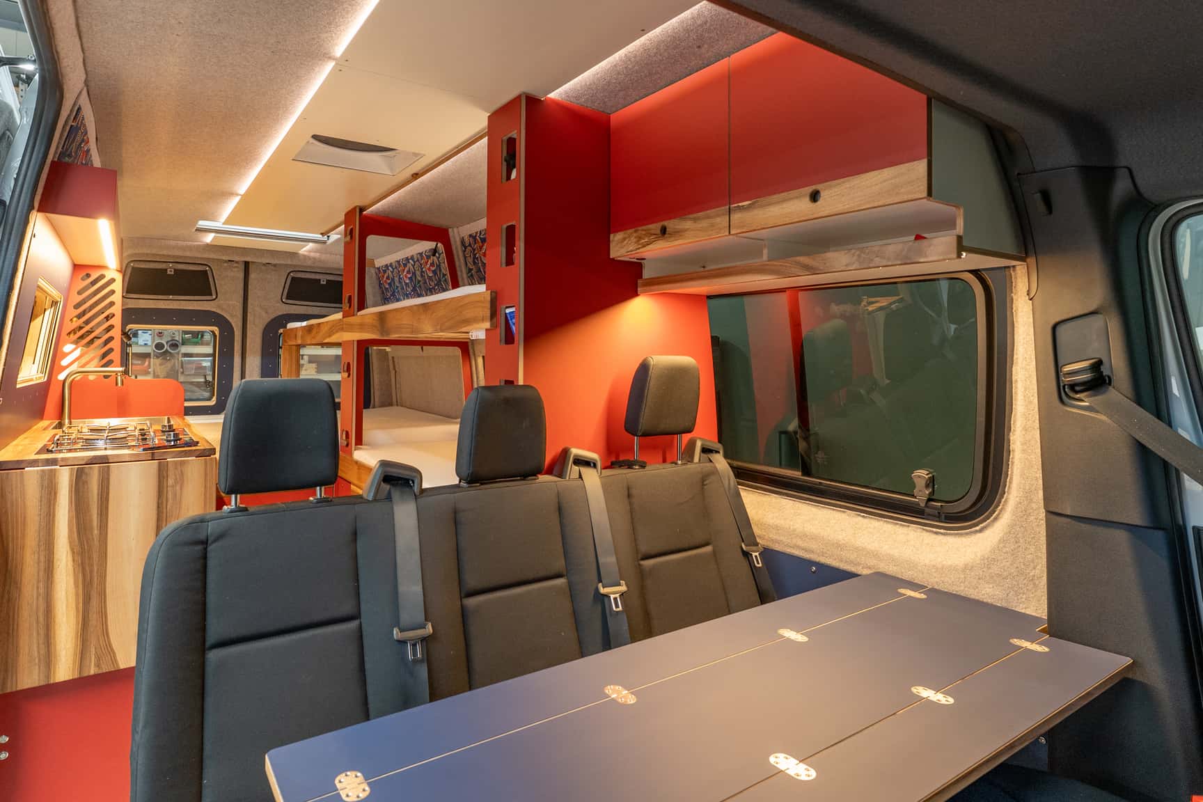 View from the passenger seat into the Sprinter L3H2 conversion with kitchen run and bunks